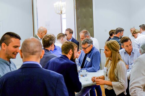 Eine Gruppeninteraktion bei einer Networking-Veranstaltung mit mehreren Personen.