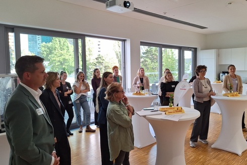 Gruppe von Personen in einem hellen Raum bei einem Networking-Event.