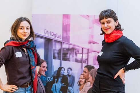 Zwei junge Frauen vor einem Roll-up