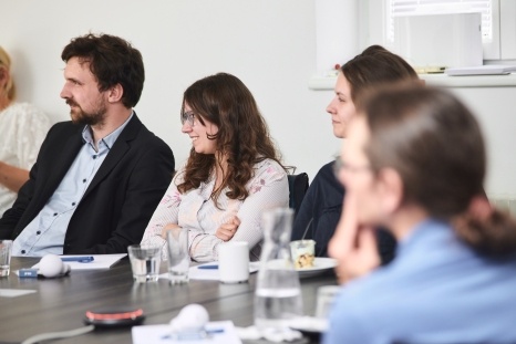 Eine Gruppe von Personen hört aufmerksam während eines Meetings zu.
