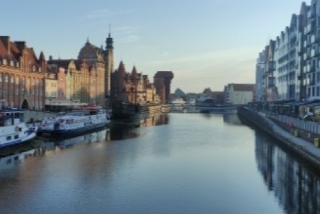 Blick auf einen ruhigen Kanal mit historischen Gebäuden und Booten in der Nähe.