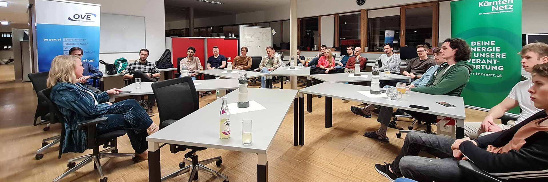 Eine Gruppe von Menschen sitzt in einem Besprechungsraum und diskutiert.