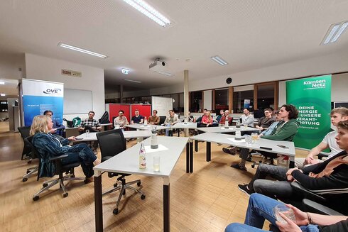 Eine Gruppe von Menschen sitzt in einem Besprechungsraum und diskutiert.