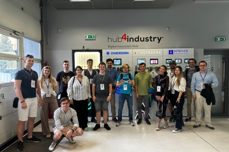 Gruppe von Menschen in einem Innovationszentrum mit Schildern im Hintergrund.