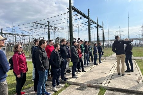 Gruppe von Menschen hört einer Präsentation in einem Elektrowerk zu.