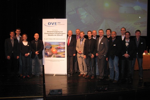 Gruppe von Menschen vor einem Banner bei einer Konferenz über Energiezukunft.