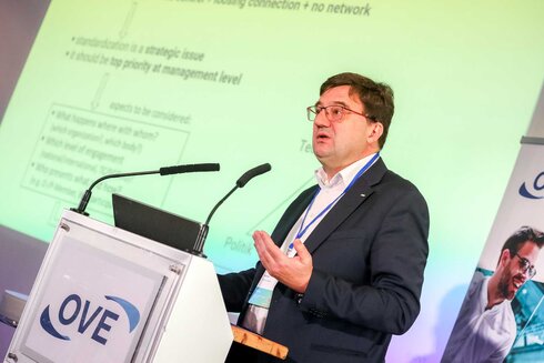 Ein Mann spricht an einem Rednerpult während einer Präsentation.