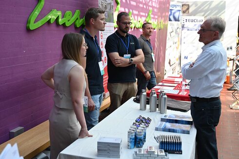 Ein Messegespräch zwischen Fachleuten an einem Stand.