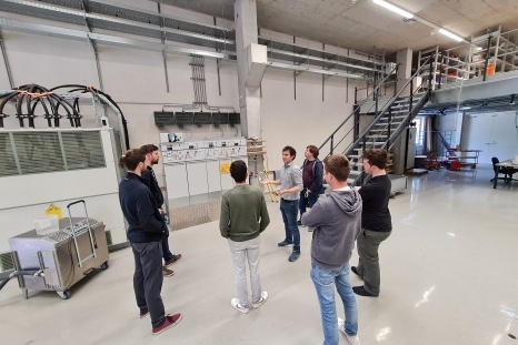 Eine Gruppe von Personen diskutiert in einem modernen Laborraum.