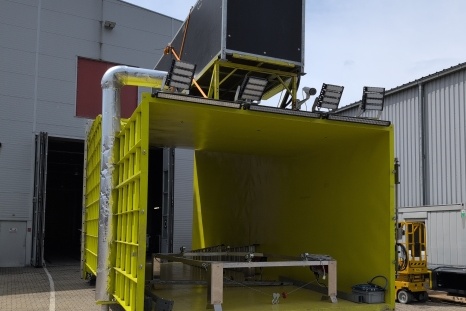Gelbe Containerstruktur mit ausgestatteter Oberseite und offenen Seiten.