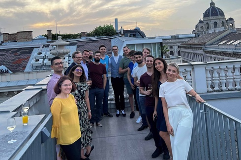Gruppe von Menschen auf einer Dachterrasse während eines Sonnenuntergangs.