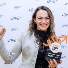 Eine Frau zeigt stolz ihren Girls Tech Up Award mit erhobener Faust.