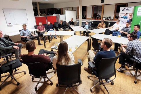 Eine Gruppe von Menschen sitzt in einem Raum und diskutiert.