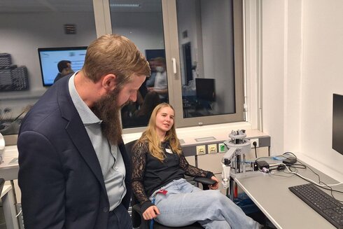 Ein Mann spricht mit einer Frau in einem modernen Büroumfeld.