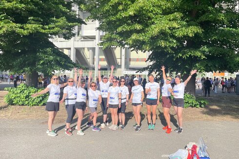 Gruppe von Frauen in T-Shirts mit lässiger Haltung und erhobenen Händen.