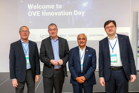 Vier Personen stehen zusammen auf einer Bühne beim OVE Innovation Day.