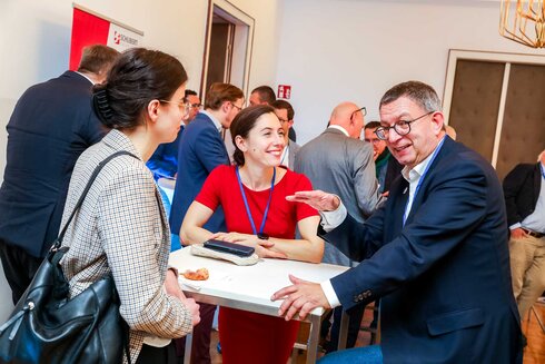 Networking-Event mit Gesprächen zwischen mehreren Personen an einem Stehtisch.