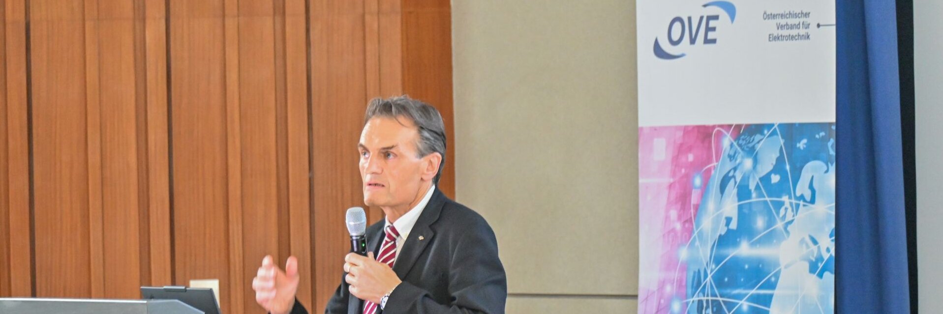 Ein Mann spricht an einem Podium bei einer Veranstaltung.