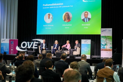 Podiumsdiskussion mit Experten zu Energiethemen auf einer Konferenz.