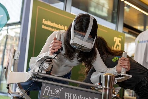 Eine Person testet eine Virtual-Reality-Brille an einem Simulator.
