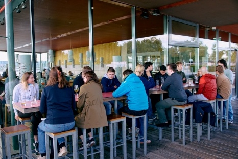 Gruppe von Menschen, die an einer Bar in einem modernen Restaurant sitzen.