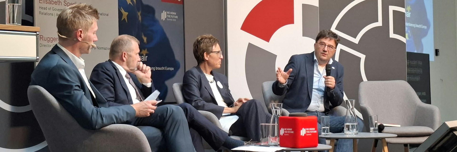 Podiumsdiskussion mit vier Personen zu Standards, mit einem Fokus auf Innovation.