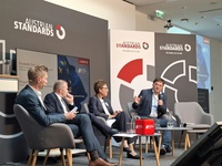 Podiumsdiskussion mit vier Personen zu Standards, mit einem Fokus auf Innovation.