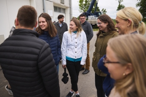Eine Gruppe von Menschen lacht und unterhält sich im Freien.