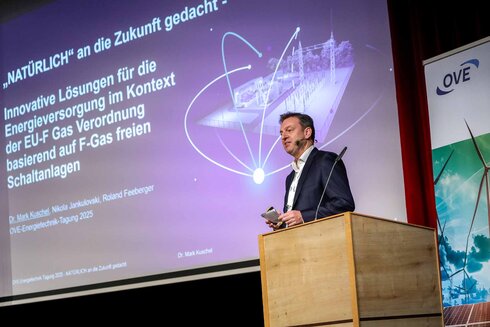 Ein Mann spricht auf einer Konferenz über innovative Lösungen zur Energieversorgung.