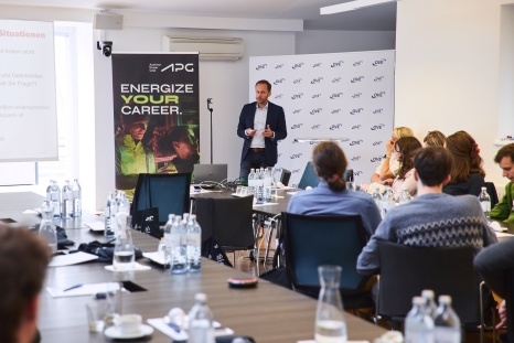 Ein Mann spricht zu einem Publikum in einem Konferenzraum.
