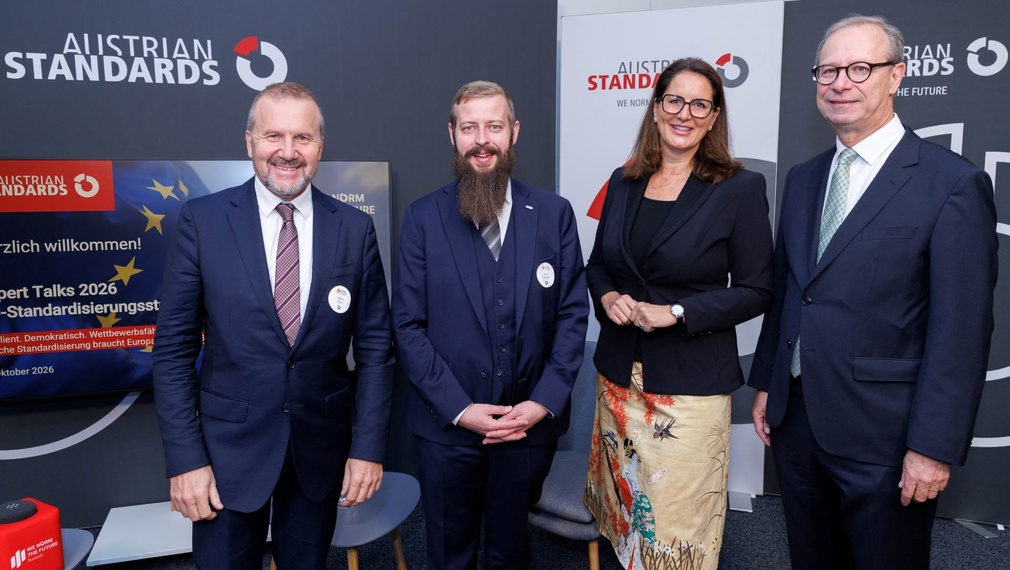 Vier Personen stehen zusammen bei einer Veranstaltung von Austrian Standards.