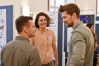 Drei Personen in einem Gespräch auf einer Veranstaltung.