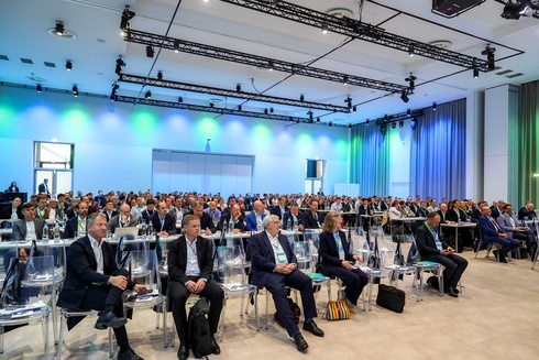 Eine große Gruppe von Menschen sitzt in einem Konferenzraum während einer Veranstaltung.