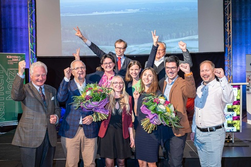 Gruppenszene mit fröhlichen Menschen, die Blumensträuße halten und jubeln.