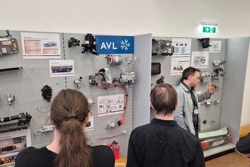 Ein Vortrag über Fahrzeugtechnologie mit verschiedenen Komponenten und Informationsplakaten.