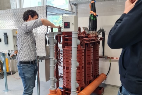 Eine Person arbeitet an einer großen technischen Vorrichtung mit Rohren und Schaltern.