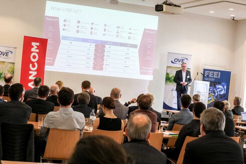 Ein Referent präsentiert Informationen über NB-IoT vor einem Publikum.