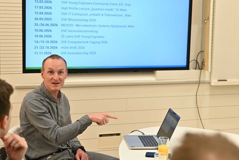 Eine Person präsentiert Informationen auf einem Laptop während eines Treffens.