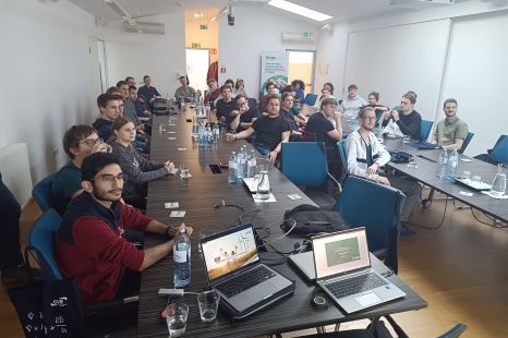 Eine Gruppe von Menschen sitzt an einem Tisch in einem Konferenzraum.