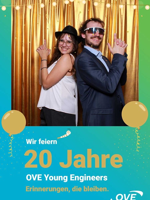 Zwei feiernde Personen posieren vor einer goldenen Kulisse für das 20-jährige Jubiläum.