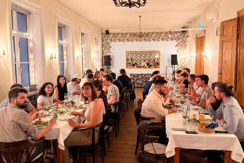 Eine Gruppe von Menschen sitzt an Tischen in einem eleganten Restaurant.