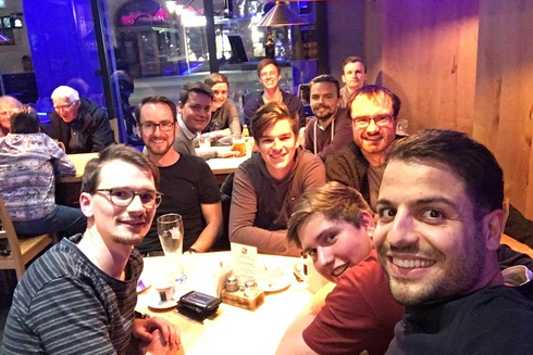 Eine Gruppe von Männern posiert lächelnd in einem Restaurant bei einem Treff.
