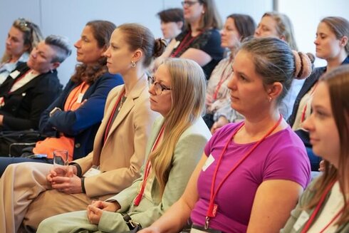 Eine Gruppe von Frauen hört aufmerksam bei einer Veranstaltung zu.