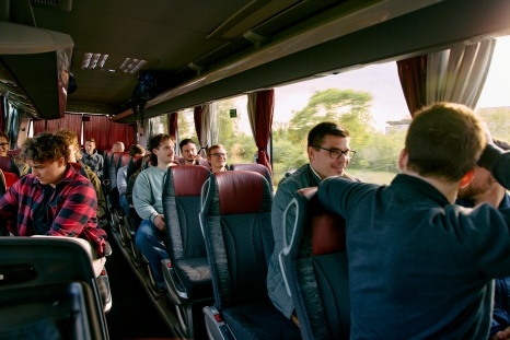 Eine Gruppe von Menschen sitzt in einem Reisebus und unterhält sich.