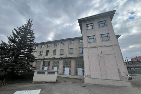 Verlassenes Gebäude mit einem hohen Turm und einem kleinen Anbau im Vordergrund.