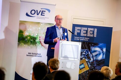 Ein Mann spricht am Podium bei einer Veranstaltung über Elektronik und Digitalisierung.
