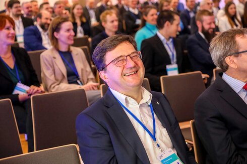 Lächelnde Menschen in einem Publikum während einer Veranstaltung oder Konferenz.