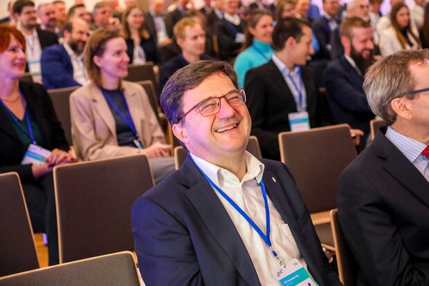Lächelnde Menschen in einem Publikum während einer Veranstaltung oder Konferenz.