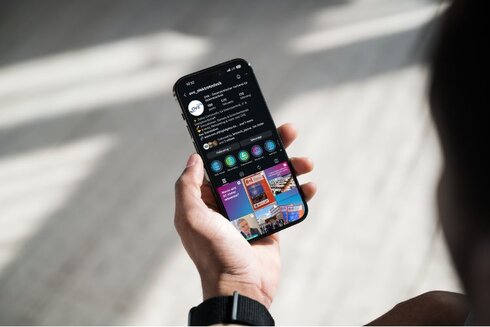 Ein Mensch hält ein Smartphone mit einer sozialen Medien-App in der Hand.