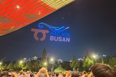 Lichtershow mit dem Text „IAAF 2023 BUSAN“ am Nachthimmel.